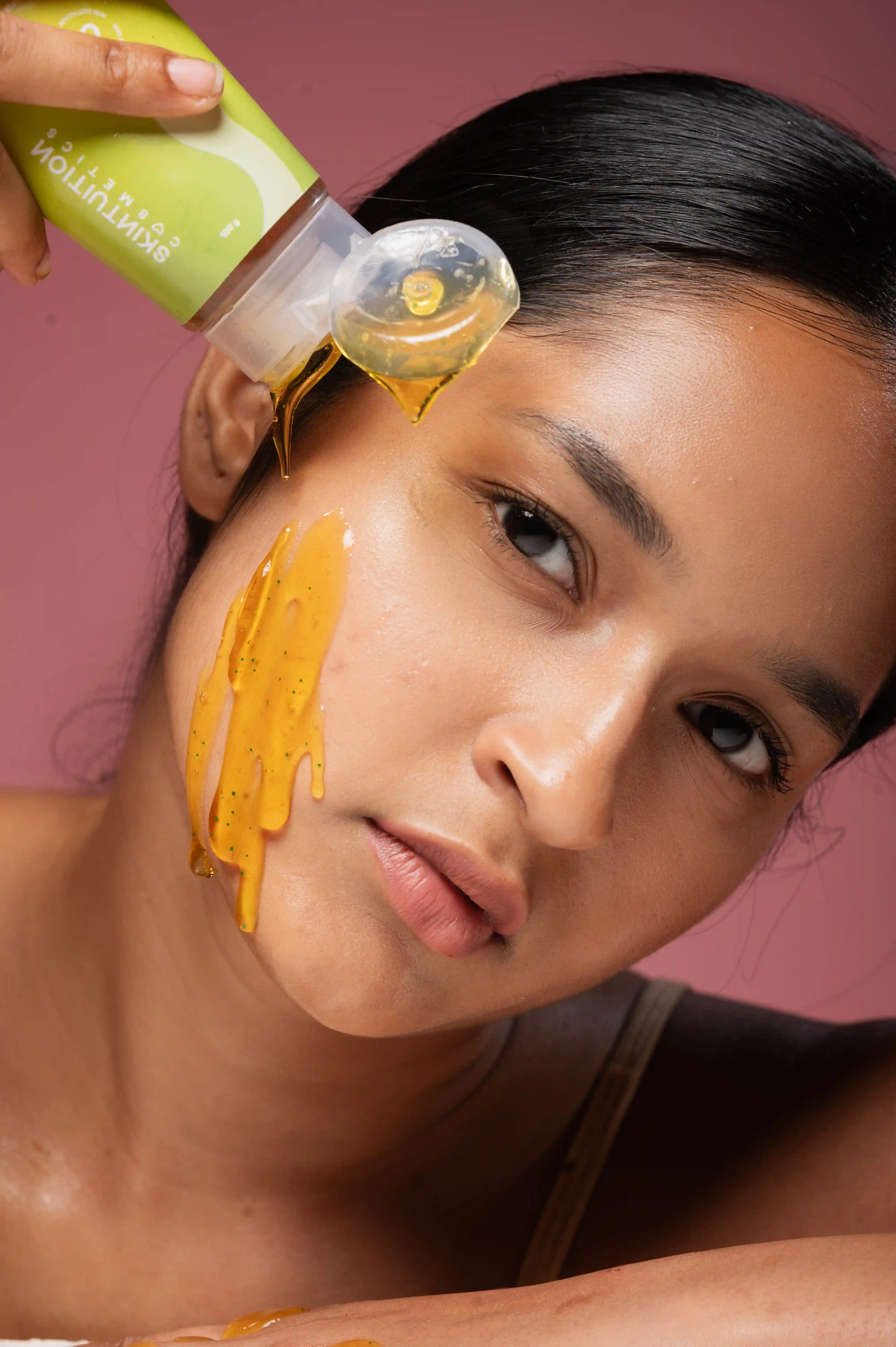 Indian young adult woman applying Skintuition Cosmetics' Amla & Curcumin face cleanser for oily and acne-prone skin