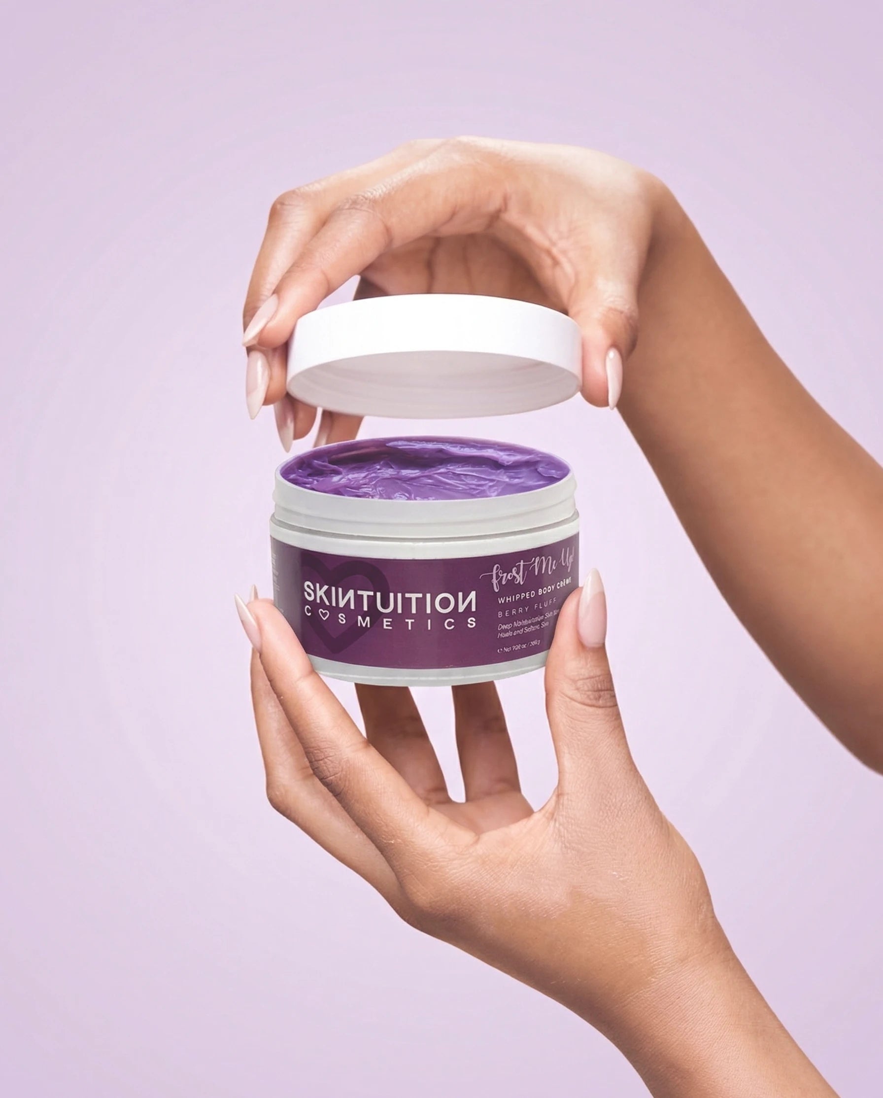 Hand holding Skintuition Cosmetics Berry Fluff whipped body cream, a lightweight non-greasy body butter for soft glowing skin